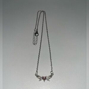 Small silver necklace with pink pendant and silver wings.
